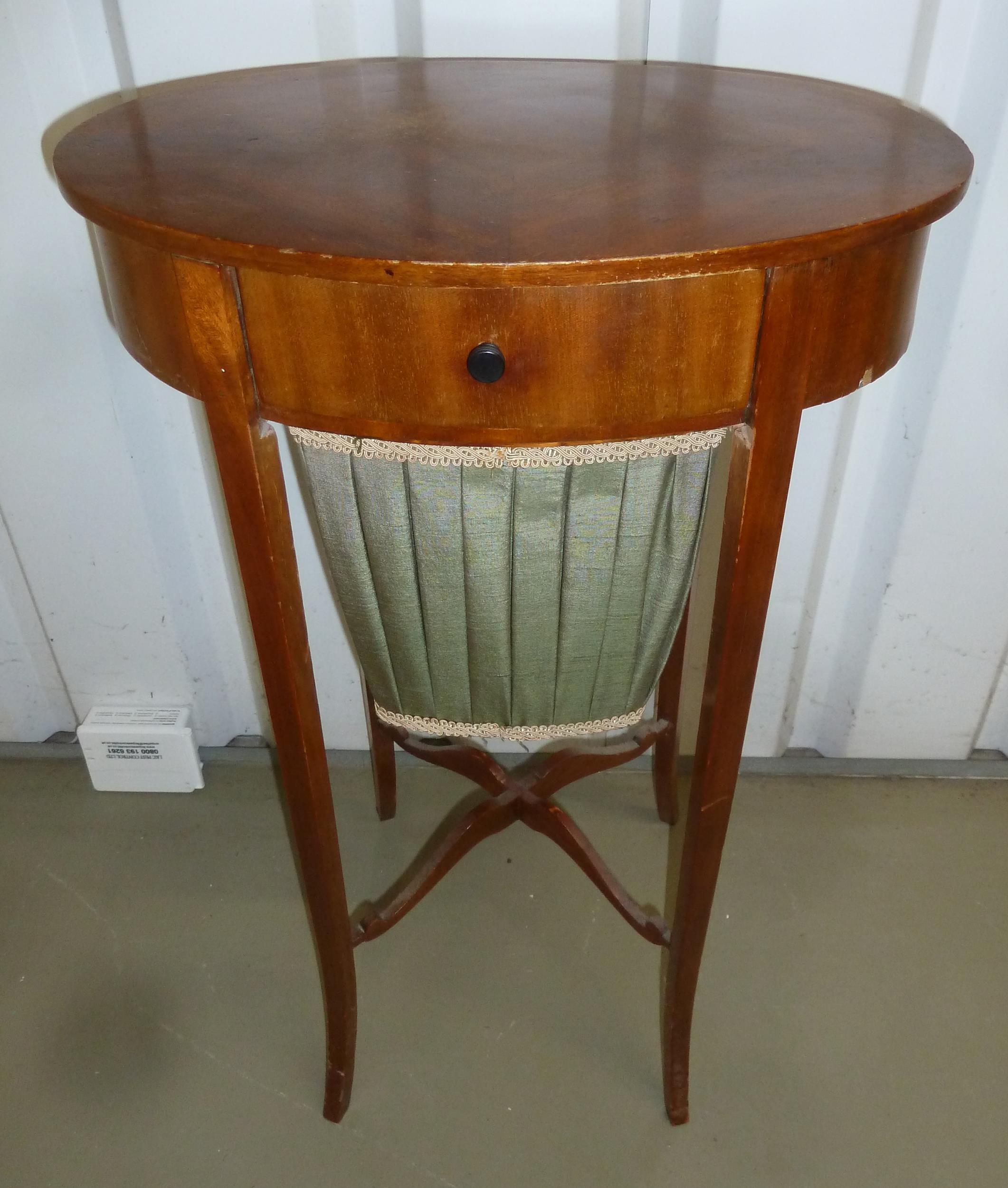 A shaped oval mahogany sewing table with single drawer on four tapering rectangular outswept legs,