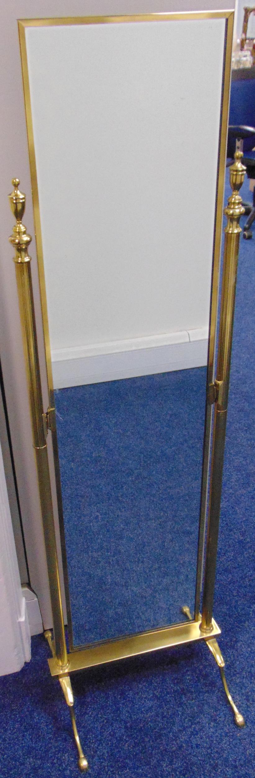 A rectangular brass cheval mirror, the flanking supports with urn finials on four scroll legs, 138 x