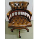 A mahogany and leatherette Captains chair on original brass castors