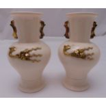 A pair of Chinese Dehua vases with applied gilded decoration and side handles, 22cm (h)