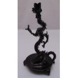 A Chinese 19th century style bronze candle holder in the form of a dragon on circular base with