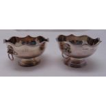 A pair of hallmarked silver bowls with lion mask side handles on raised circular bases, Sheffield