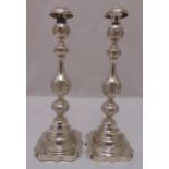 A pair of hallmarked silver table candlesticks, knopped baluster form chased with leaves and