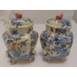 A pair of Japanese ceramic storage jars decorated with birds, flowers and leaves on four figural