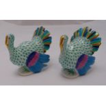 A pair of Herend fishnet peacocks on shaped oval bases, marks to the bases, 11.5cm (h)