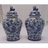 A pair of Chinese blue and white baluster form vases with pull covers decorated with flowers,