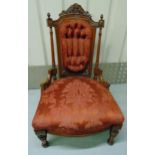 A Victorian mahogany upholstered nursing chair on four turned cylindrical legs