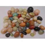 A quantity of coloured stone eggs and spheres of varying size and shape