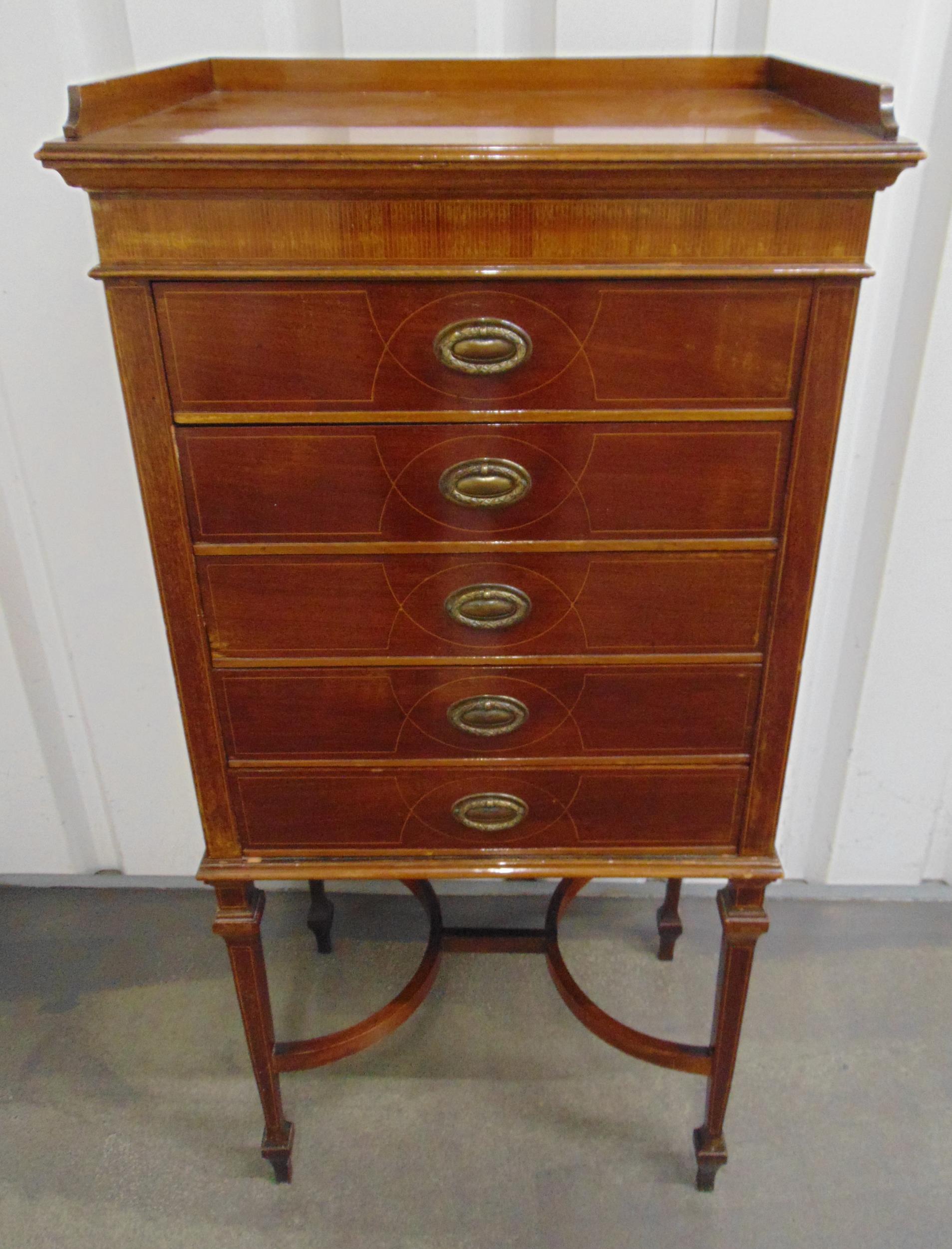 An Edwardian mahogany rectangular music cabinet, the five drawers with brass swing handles, on