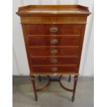 An Edwardian mahogany rectangular music cabinet, the five drawers with brass swing handles, on