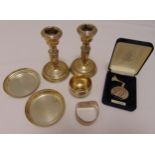 A quantity of hallmarked silver to include a pair of candlesticks, a pair of coasters, a napkin