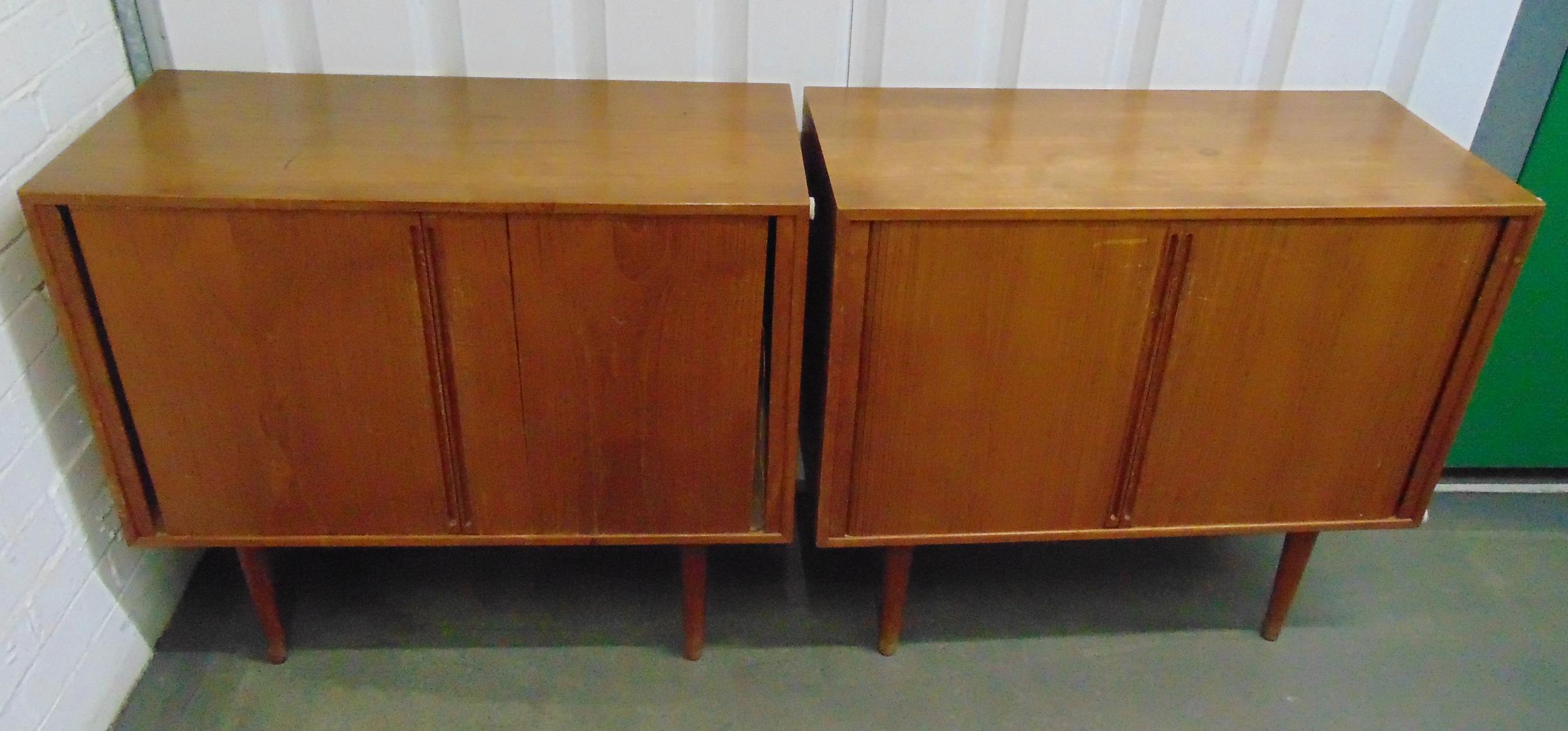 A pair of mid 20th century rectangular teak cabinets with sliding doors on four tapering cylindrical