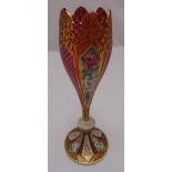 A Bohemian overlaid ruby vase decorated with panels of flowers and leaves on raised circular base,