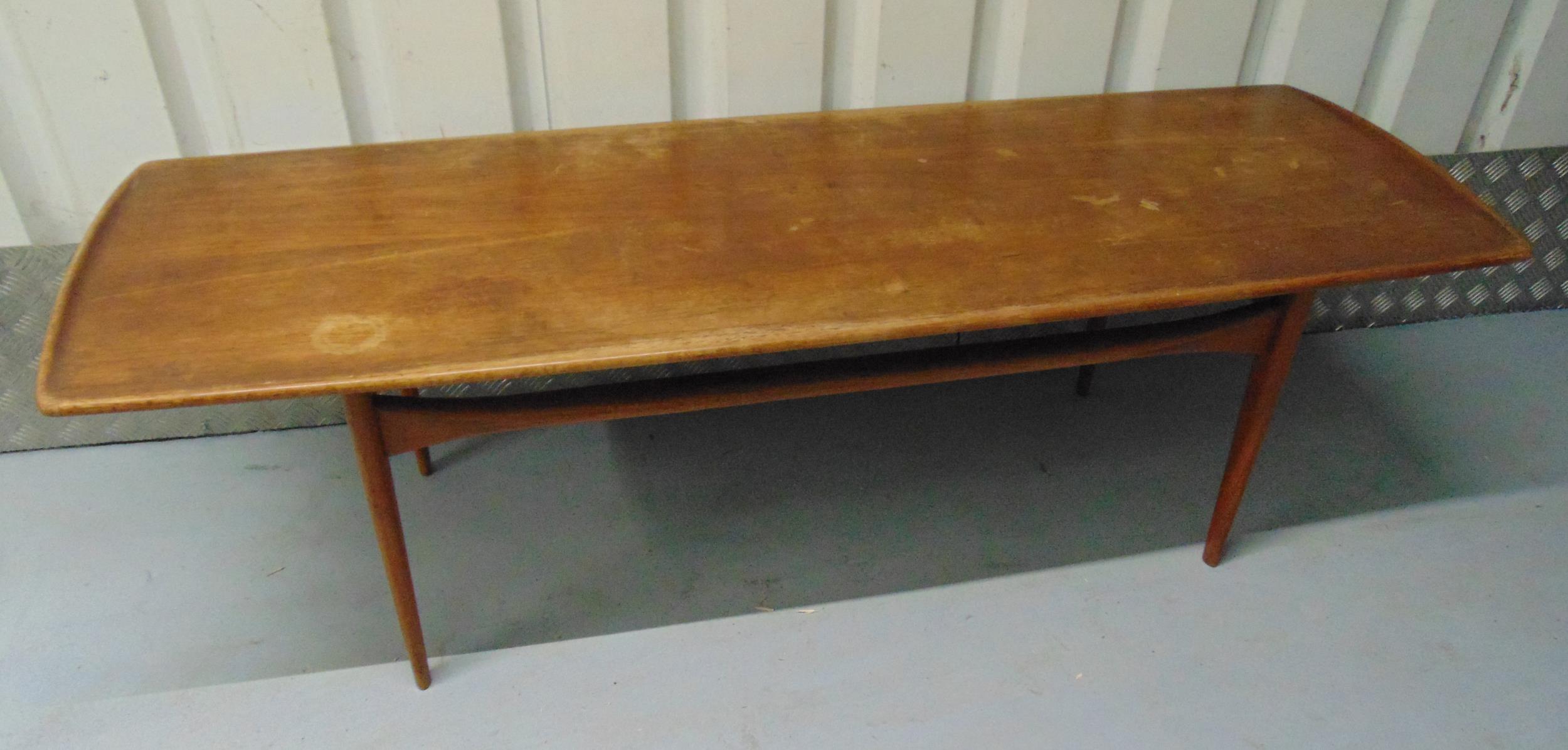 A mid 20th century rectangular teak coffee table on four tapering cylindrical legs, 47 x 150 x 52.