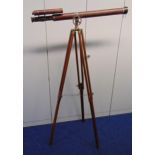 An antique brass and leather bound telescope on brass mounted wooden tripod stand