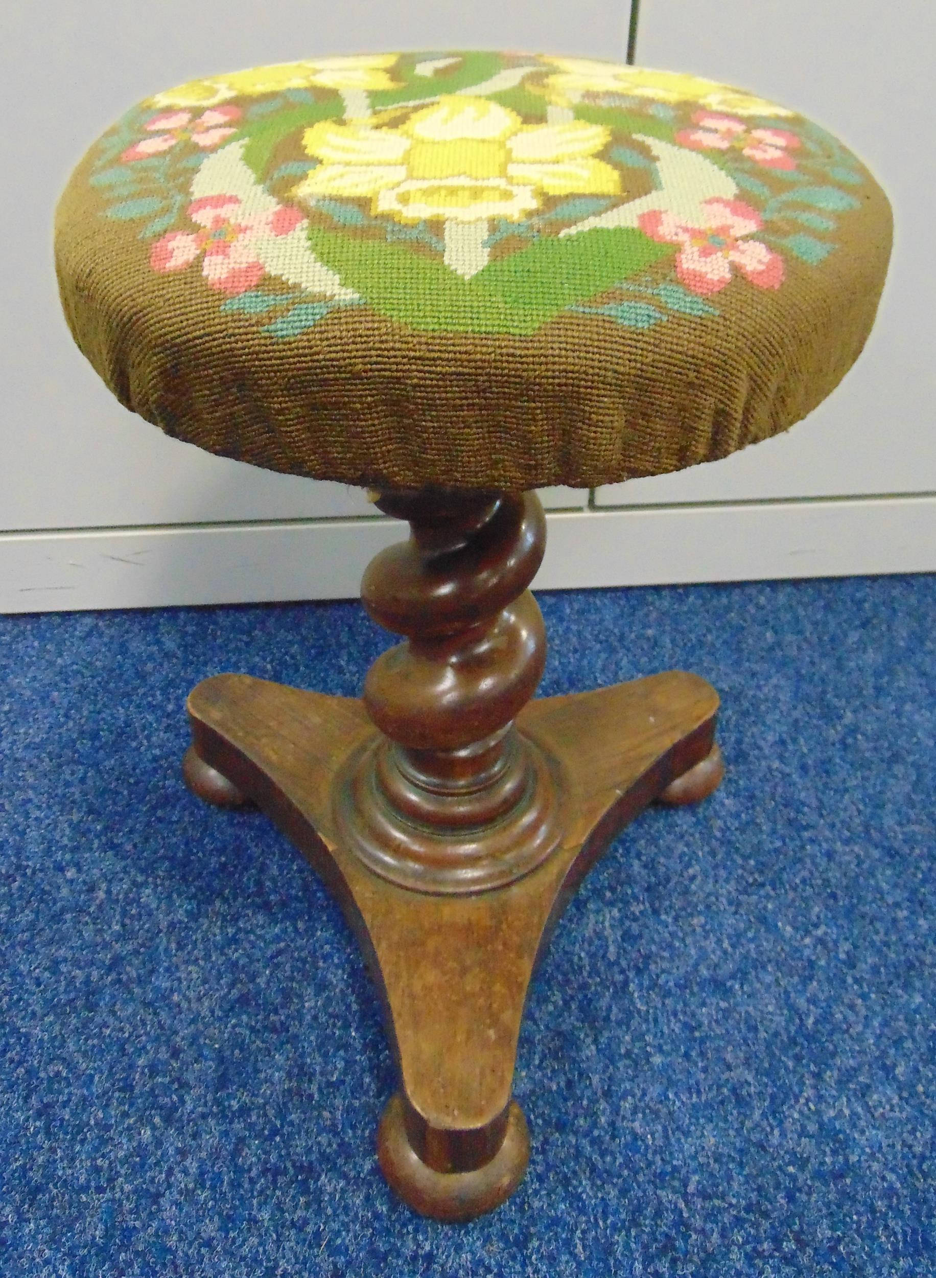 A Victorian rise and fall piano stool with barley twist column on triform base with embroided