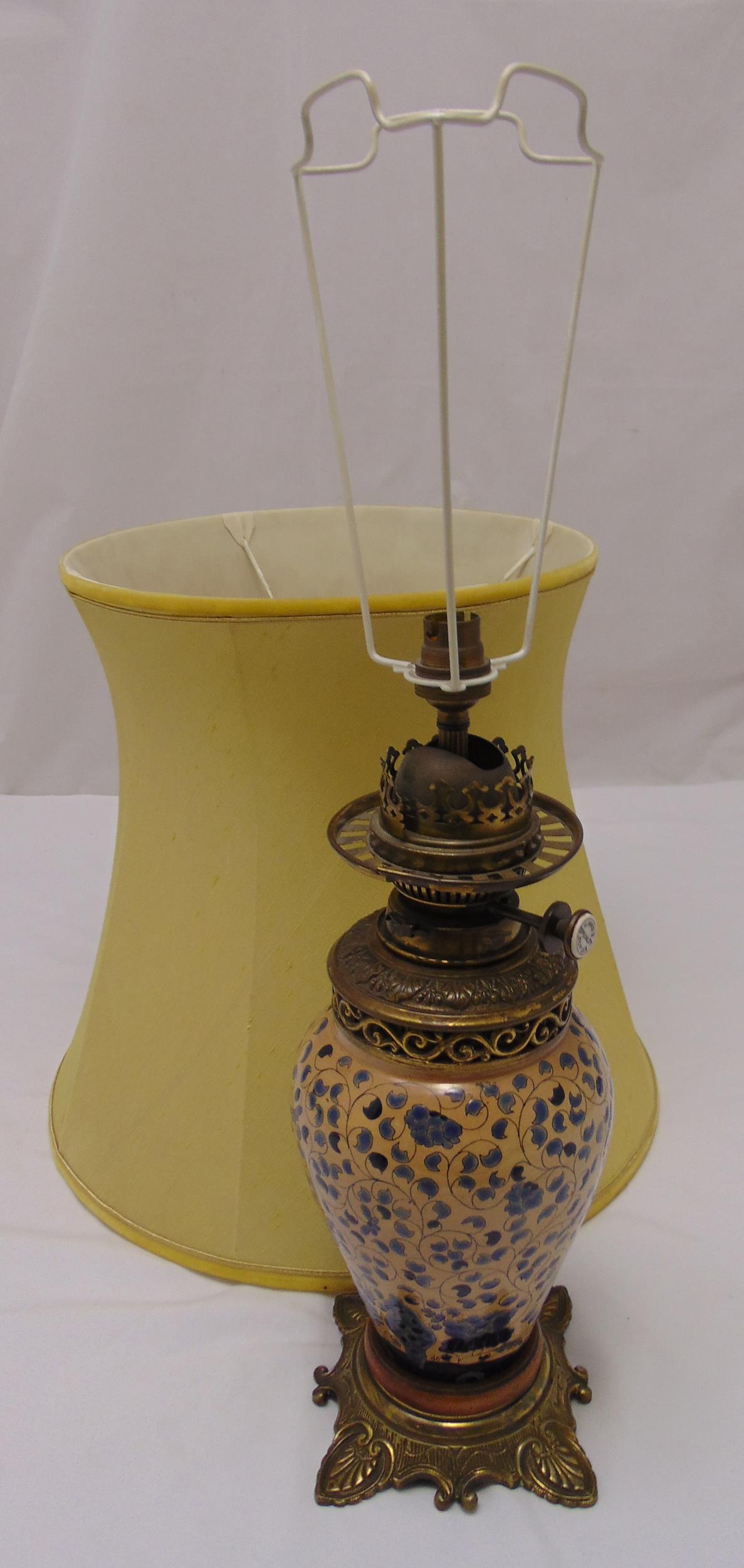 A Victorian oil lamp with baluster ceramic body on raised square base with shell feet, converted