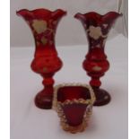 A pair of Victorian ruby glass vases, vine leaf decoration on raised circular bases and a ruby red