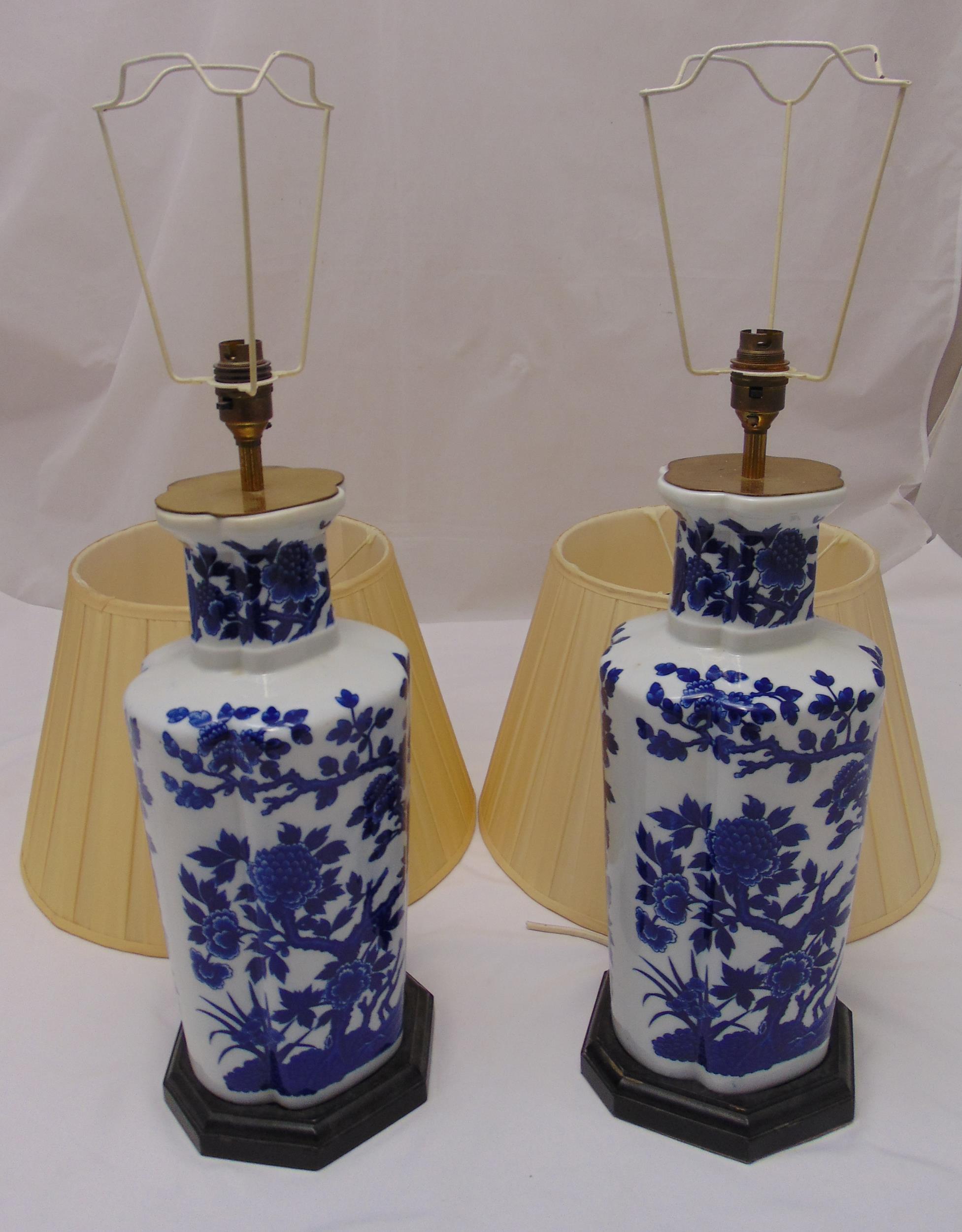 A pair of blue and white Chinese style table lamps on octagonal bases with detachable silk shades,