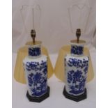 A pair of blue and white Chinese style table lamps on octagonal bases with detachable silk shades,