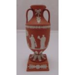 A Wedgwood Jasperware terracotta twin handle pedestal urn vase decorated with muses and acanthus