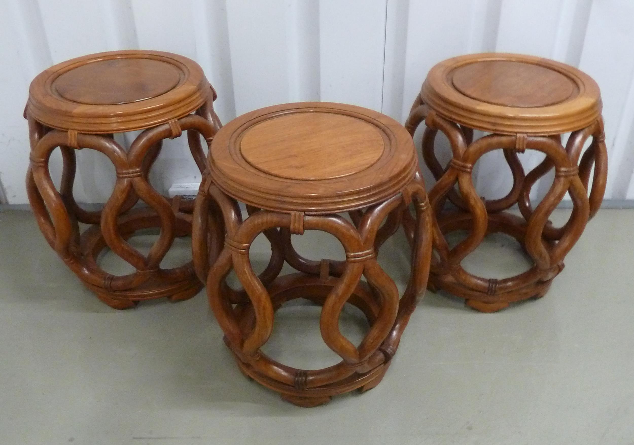 Three oriental barrel shaped hardwood stools with scroll pierced sides on bracket feet, 45 x 43cm