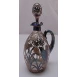 A continental glass and overlaid white metal claret jug with drop stopper decorated with stylised