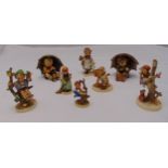 Eight Goebel figurines of children in various pursuits on raised oval bases, marks to the bases