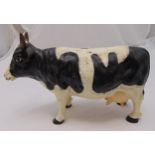 A cast iron money box in the form of a cow, 29x 43 x 16cm