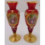 A pair of ruby glass vases, baluster form decorated with courting scenes on raised circular bases,