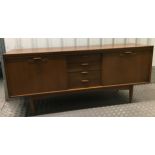 A mid 20th century rectangular teak sideboard with hinged cupboards and drawers on four tapering