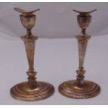 A pair of hallmarked silver table candlesticks, tapering oval on stepped oval base with vase form