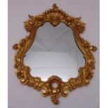 A gilded wooden wall mirror carved in the Baroque style with leaves and flowers, 91 x 65cm