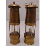 A pair of brass safety lamps of customary form with suspensory hooks, 30cm (h)