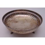 A hallmarked silver circular fruit dish, scroll pierced sides, gadrooned border on four hoof feet,