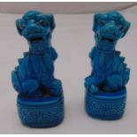 A pair of Chinese blue ground dogs of foe on rounded rectangular bases, 12cm (h)