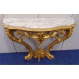 A gilded carved wooden consol table of oval form with detachable marble top, 81.5 x 106.5 x 41cm