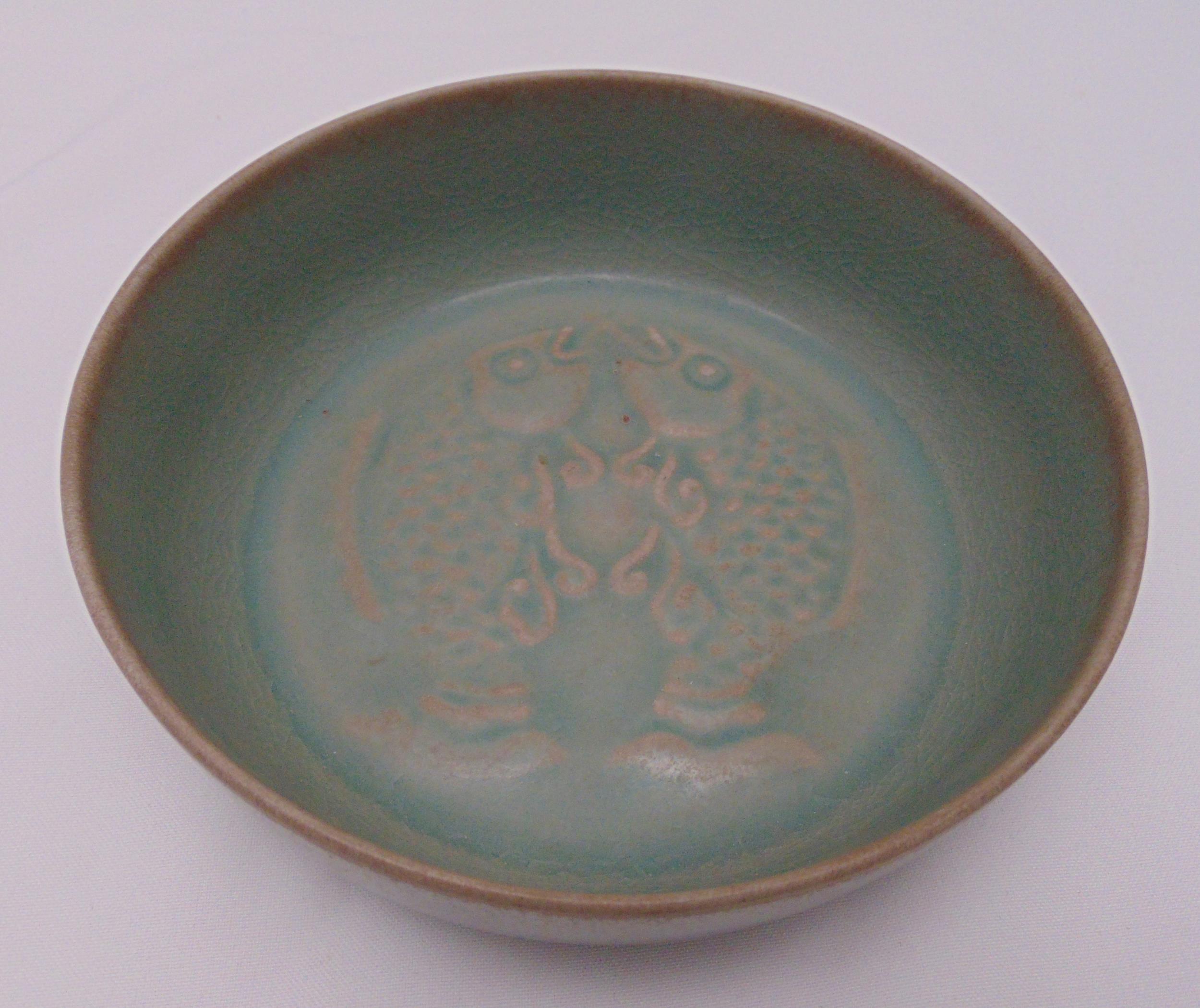 A Chinese celadon dish, decorated with stylised fish to the centre, marks to the base, 18.5cm (d)