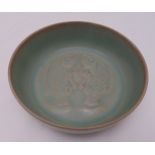 A Chinese celadon dish, decorated with stylised fish to the centre, marks to the base, 18.5cm (d)