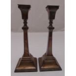 A pair of hallmarked silver table candlesticks, tapering rectangular on raised square bases with