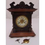 An early 20th century oak cased mantle clock of architectural form, two train movement, enamel