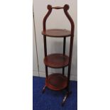 A mahogany three tier plate stand of customary form on scroll supports, 87.5cm (h)