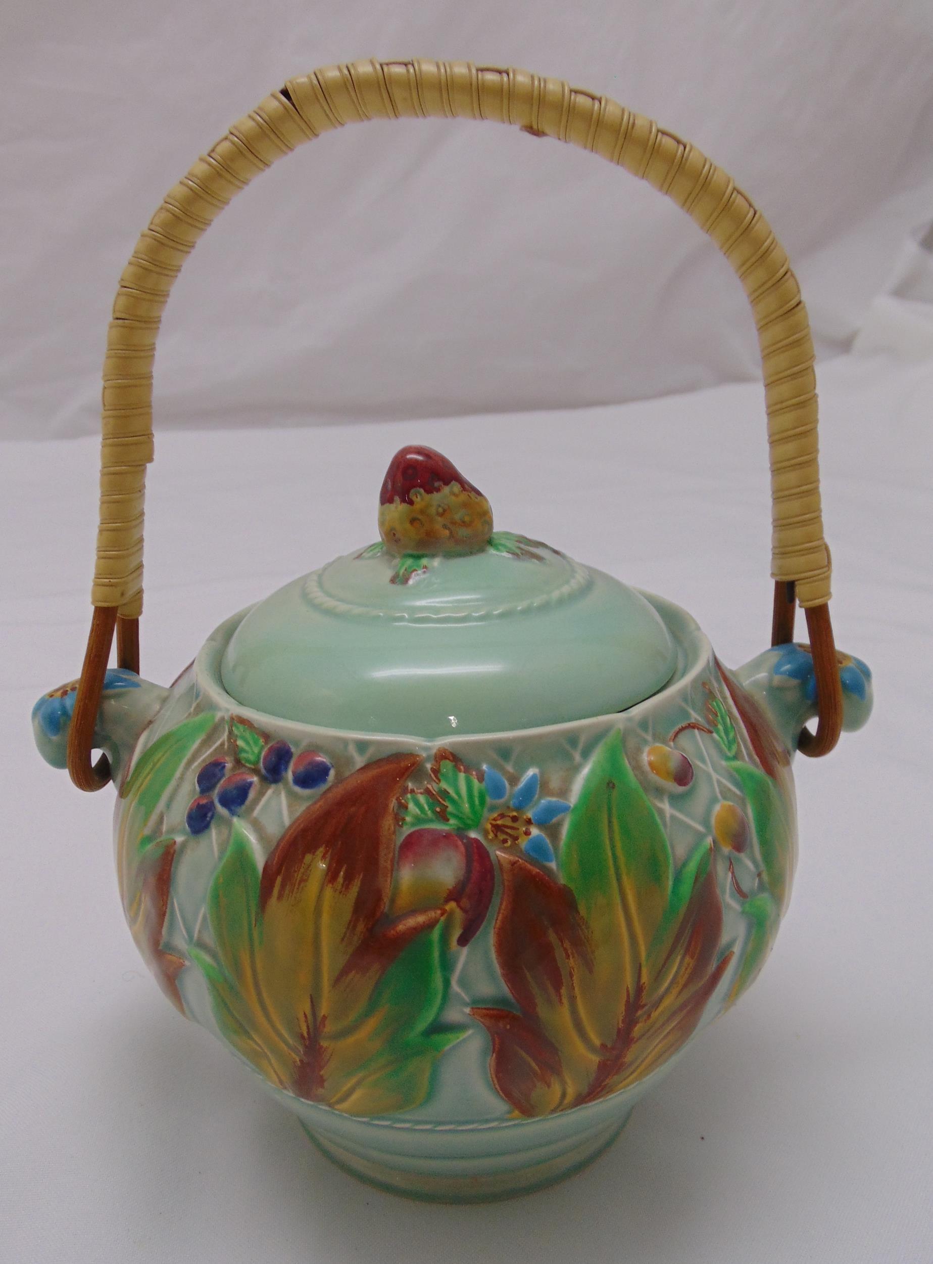 Clarice Cliff biscuit jar and cover decorated to the sides with stylised leaves and berries with