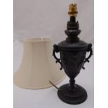 A cast metal table lamp stand with two side handless decorated with putti and scrolls on raised
