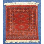 A Middle Eastern red ground prayer mat with repeating geometric patterns, 66 x 60.5cm