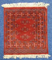 A Middle Eastern red ground prayer mat with repeating geometric patterns, 66 x 60.5cm