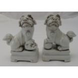 A pair of Chinese blanc de chine of dogs of foe on raised rectangular bases, 12 x 8.5 x 4cm each