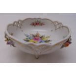 A continental porcelain bowl, pierced sides decorated with floral sprays on three bracket feet,