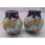 A pair of oriental baluster vases decorated with flowers and leaves, marks to the bases, 19cm (h)