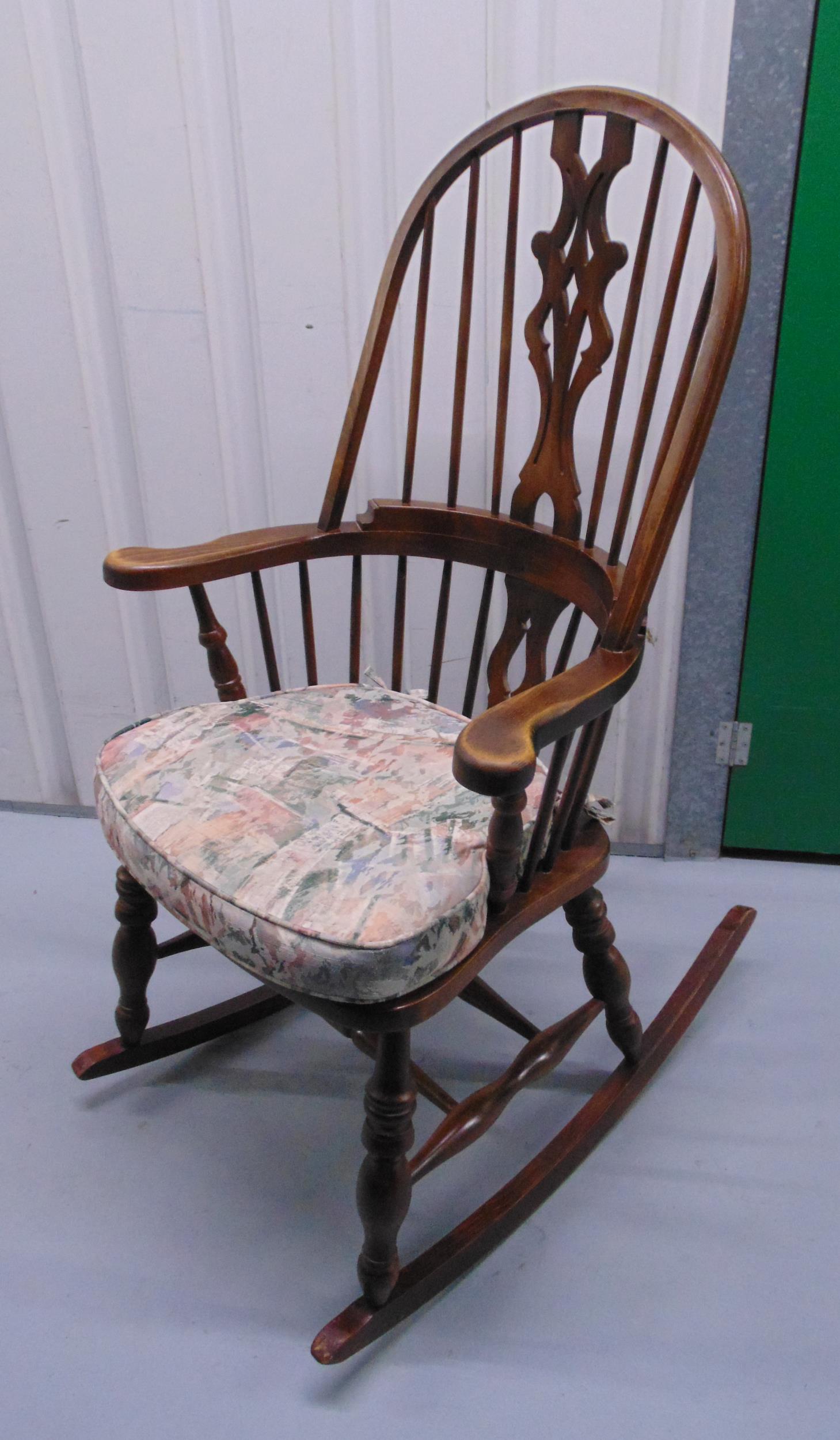 An oak rocking chair, spindle back, scrolling arms on turned supports
